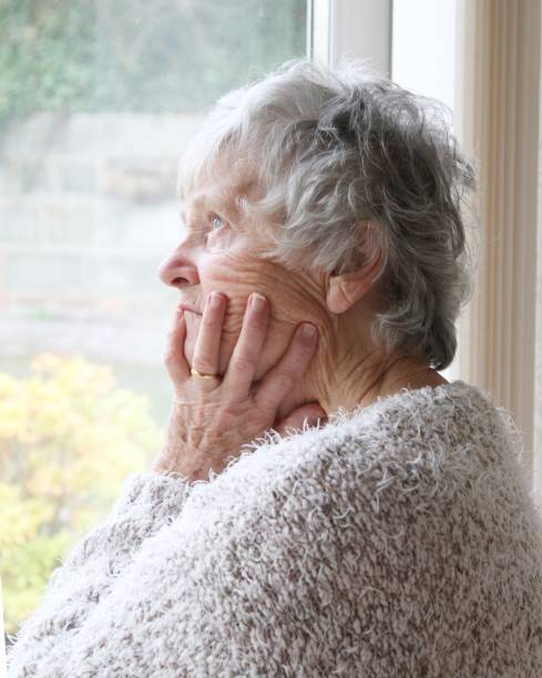 istock senior woman with thoughtful expression looking out of window 1096878584
