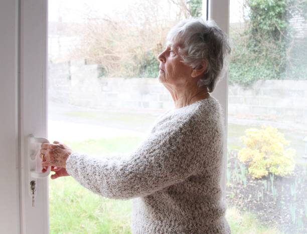 istock Nosey neighbour , senior woman looking through window 1096878590