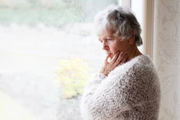 istock senior woman with thoughtful expression looking out of window 1096878592
