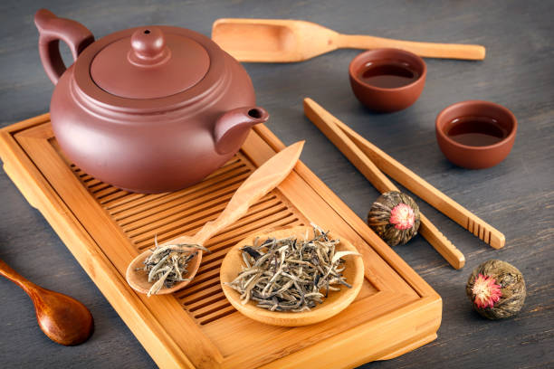 istock green tea and attributes for tea ceremony - a ceramic teapot, cups, a strainer, chopsticks and tweezers are placed on an old wooden table 1096883928
