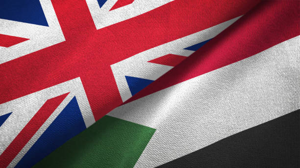 istock Sudan and United Kingdom two flags together textile cloth, fabric texture 1096910220