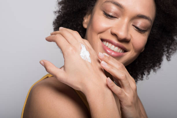 istock Smiling woman putting moisturizer on hands 1096911126