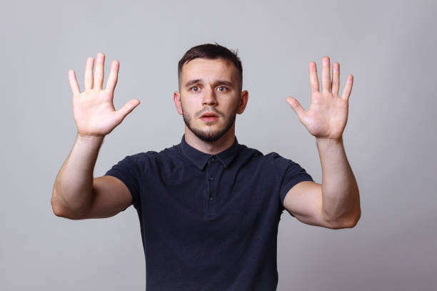istock Studio portrait of a young man keep hands up before him with the expression 