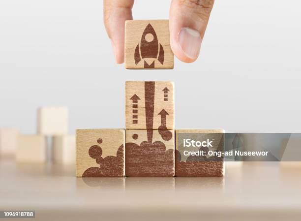 Business Startup Start Neues Projekt Oder Eine Neue Ideekonzept Holzklötze Mit Dem Start Der Rakete Grafik In Pyramidenform Angeordnet Und Ein Mann Hält Die Obere Stockfoto und mehr Bilder von Geschäftsgründung