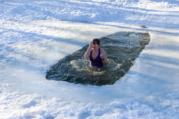 istock A woman is baptized after dipping into ice water. 1096920338