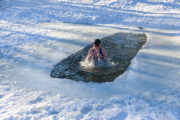 istock A woman emerges from the ice hole. Baptism day 1096920342