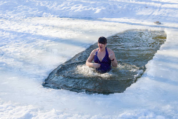istock A woman emerges from the ice hole. Baptism day 1096920362