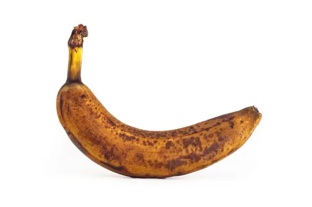 Brown single overripe banana isolated against white backgroud