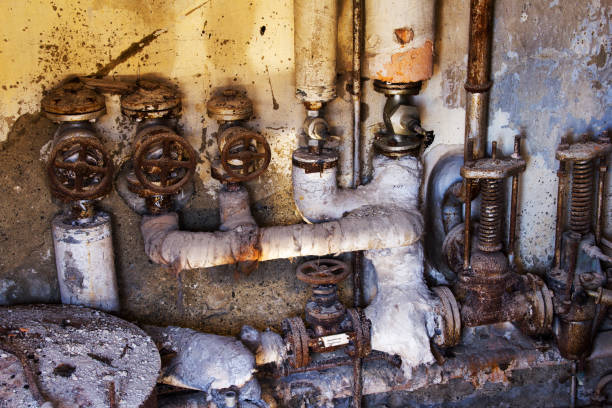 opuszczona maszyna zardzewiałych rur i brudnych zaworów z ciekawym naturalnym oświetleniem - water pipe rusty dirty equipment zdjęcia i obrazy z banku zdjęć