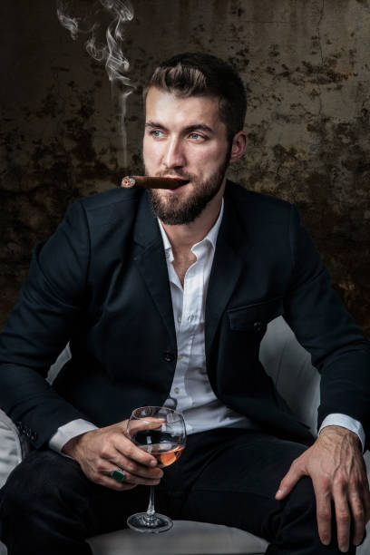 istock Attractive man with a cigar and a drink 1096926298