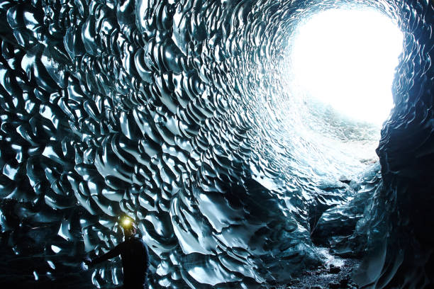 istock Man with Headlamp standing in black ice cave moulin, iceland 1096926704