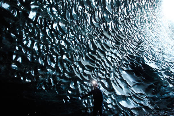 istock Man with Headlamp standing in black ice cave moulin, iceland 1096926706