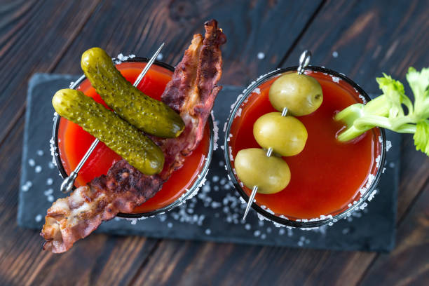 Two glasses of Bloody Mary Two glasses of Bloody Mary garnished with gherkins and celery stalk bloody mary stock pictures, royalty-free photos & images