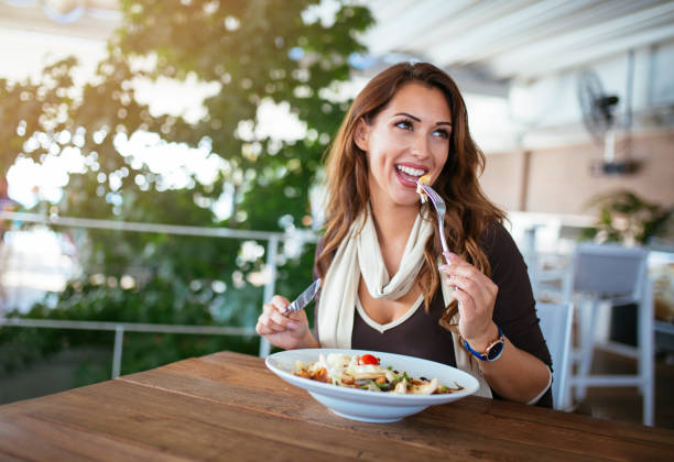 istock Happy woman eating fresh salad at restaurant 1096928014