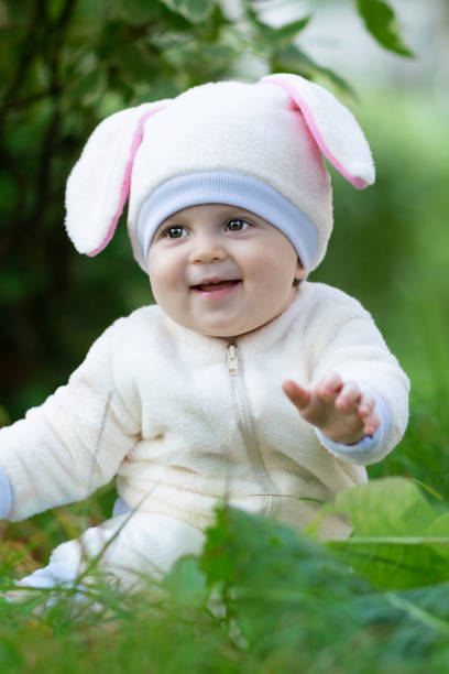istock Baby in rabbit costume sitting on grass in park and smiling 1096929704