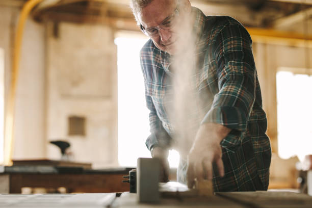 istock Senior carpenter cutting wood on table saw machine 1096931788