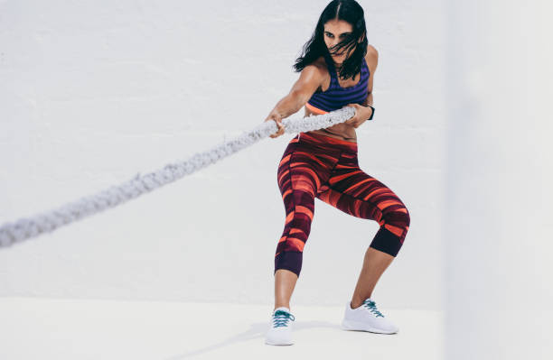 istock Fitness woman doing strength training using a battle rope 1096932378