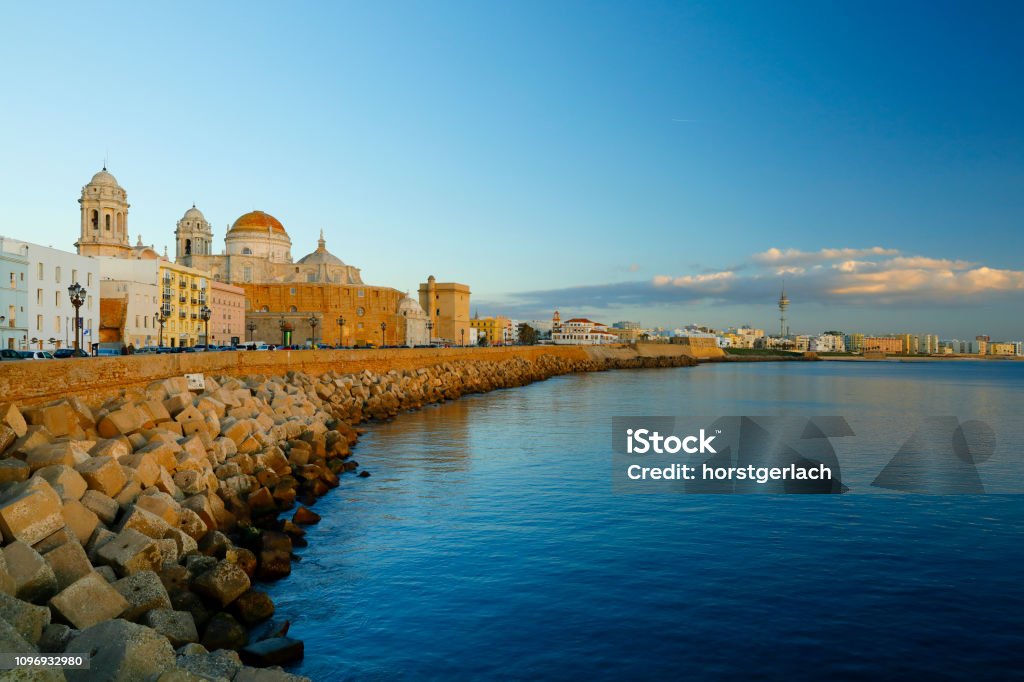 Promenade with the New Cathedral at sunset. Cadiz, Andaluse, Spain Promenade with the protection wall and the New Cathedral at Cadiz, Andaluse, Spain Cádiz Stock Photo