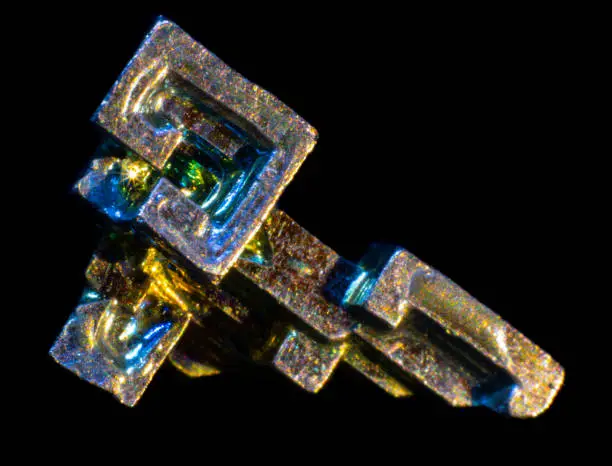 Synthetic iridescent stone bismuth macro on black background isolated