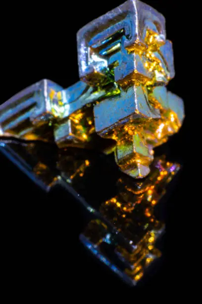 Synthetic iridescent stone bismuth macro on black background isolated