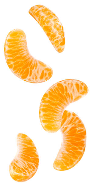 isolati segmenti arancioni in caduta. - mandarino foto e immagini stock
