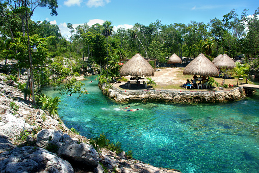 this nice cenote offers clear waters for swimming, buildings for picnic and is a popular weekend destination for tourists and local families in Tulum, Yucatan, Mexico, 2015