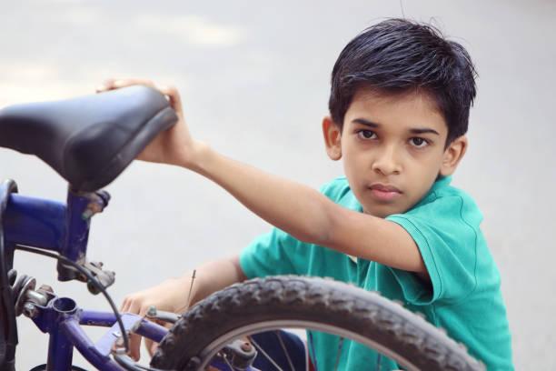istock Indian Little Boy repairing cycle 1096947282