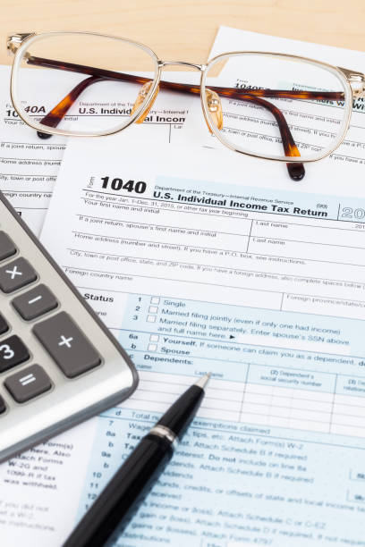 istock Tax form with pen, glasses, and calculator 1096948772