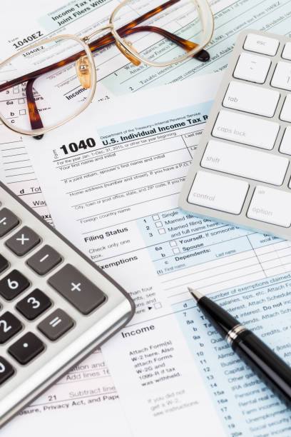 istock Tax form with calculator, pen, glasses, and keyboard 1096948820