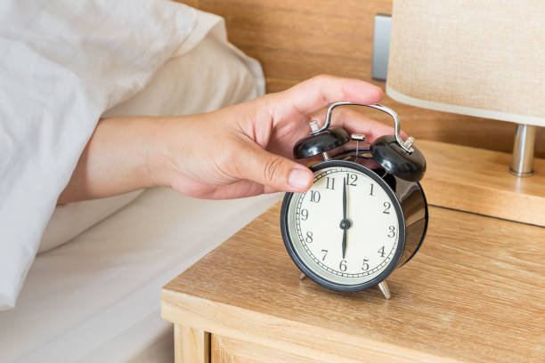 istock Man extend hand reaching to turn off alarm clock switch 1096948878