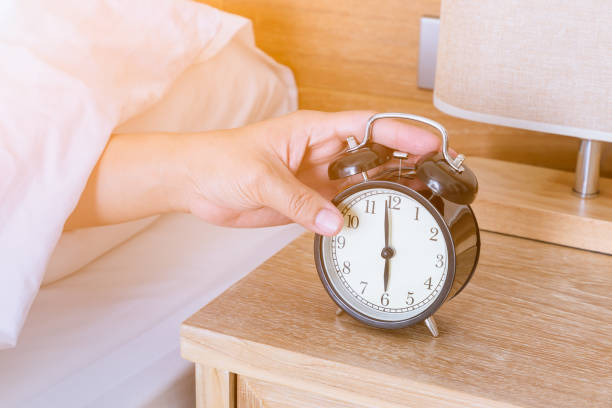 istock Man extend hand reaching to turn off alarm clock switch 1096948892