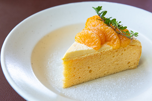 orange cake with orange fruit topping on white dish