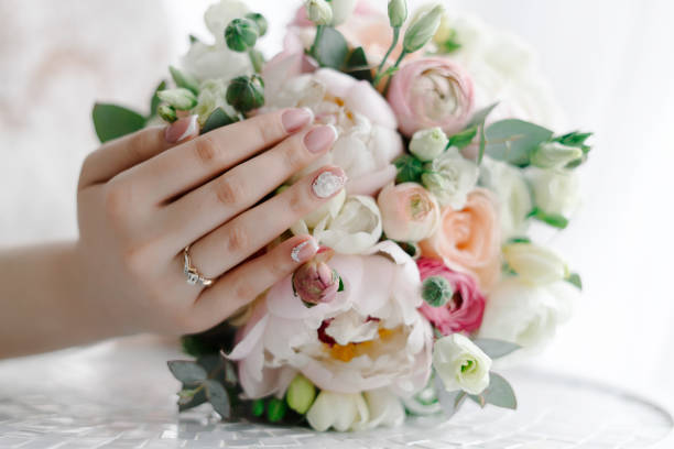 istock Bride touching wedding bouquet showing elegant wedding manicure 1096956588