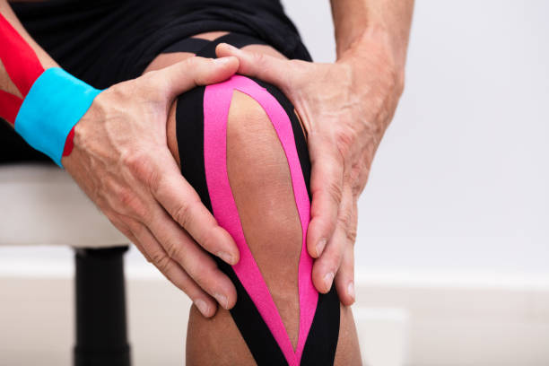 istock Man Applying Kinesiology Tape On His Knee 1096959804