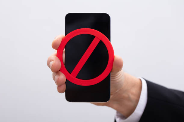 istock Hand Holding Mobile Phone With Red No Sign 1096959926