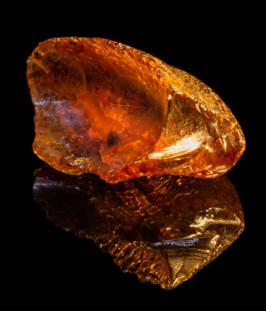 istock Natural piece of raw amber on black background with reflection 1096966828