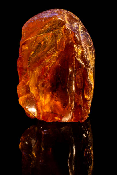 istock Natural piece of raw amber on black background with reflection 1096966830