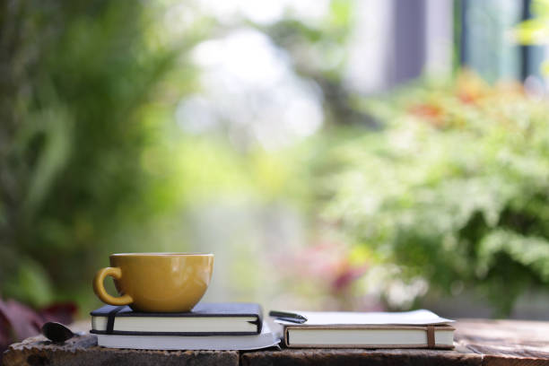 istock Yellow ceramic cup with notebooks at on wooden table 1096968466