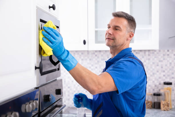 istock Male Janitor Cleaning Oven With Napkin 1096969788