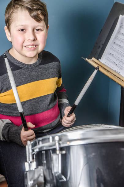 istock Young boy playing drum in his basement 1096973132