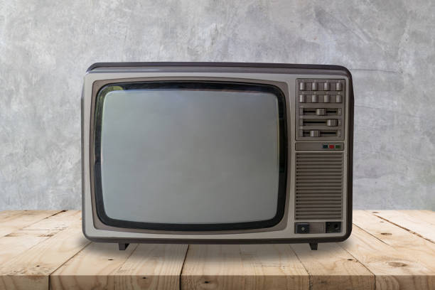 istock Vintage television on wooden table and cement wall texture and background. 1096973900