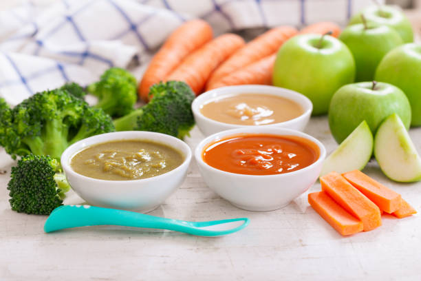 Baby food. Various bowls of fruit and vegetable puree Baby food. Various bowls of fruit and vegetable puree with ingredients for cooking on wooden table baby food stock pictures, royalty-free photos & images