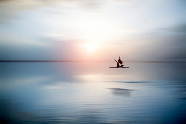 hermosa ballerine saltando y bailando en el lago en la noche - sunset sea tranquil scene sunrise fotografías e imágenes de stock