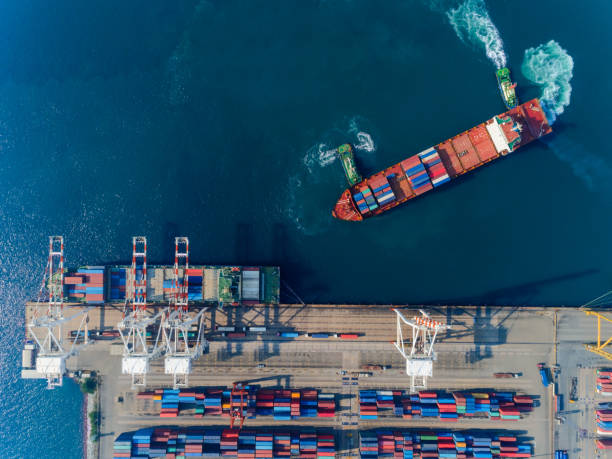 istock Aerial top view Tugboat draging container ship at sea port to working crane bridge loading container for logistics import export, shipping or transportation concept background. 1096980268