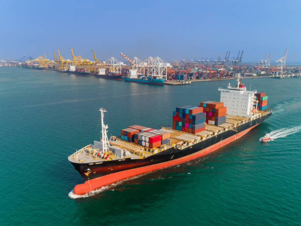 istock Container ship with sea port and working crane bridge container  warehouse background for logistic, import export, shipping or transportation. 1096980358