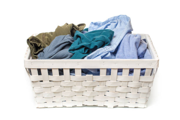 istock Clothes in a laundry wooden basket isolated on white background 1096992356