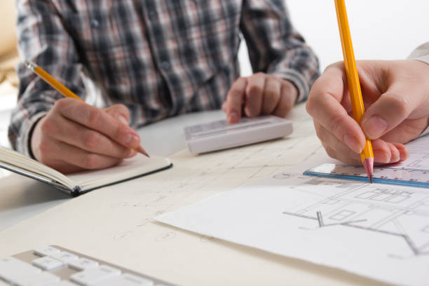 istock Architects working on blueprint, real estate project. Architect workplace - architectural project, blueprints, ruler, calculator, laptop and divider compass. Construction concept. Engineering tools. 1096995602
