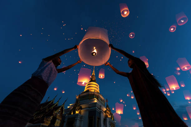 populations de femme asie libérer ballon flottant de lanternes de ciel bleu - firework explosive material photos et images de collection