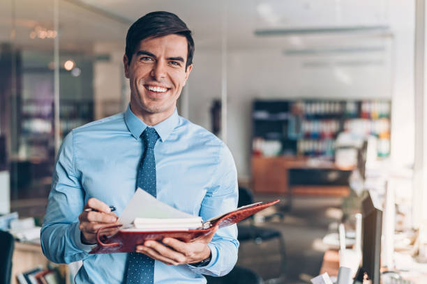 istock Smiling businessman holding a pen and organizer 1097008590