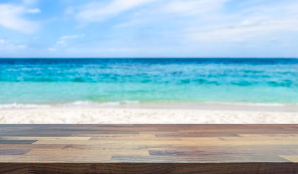 istock Empty table top for product display with tropical paradise beach and ocean in the background. 1097010458